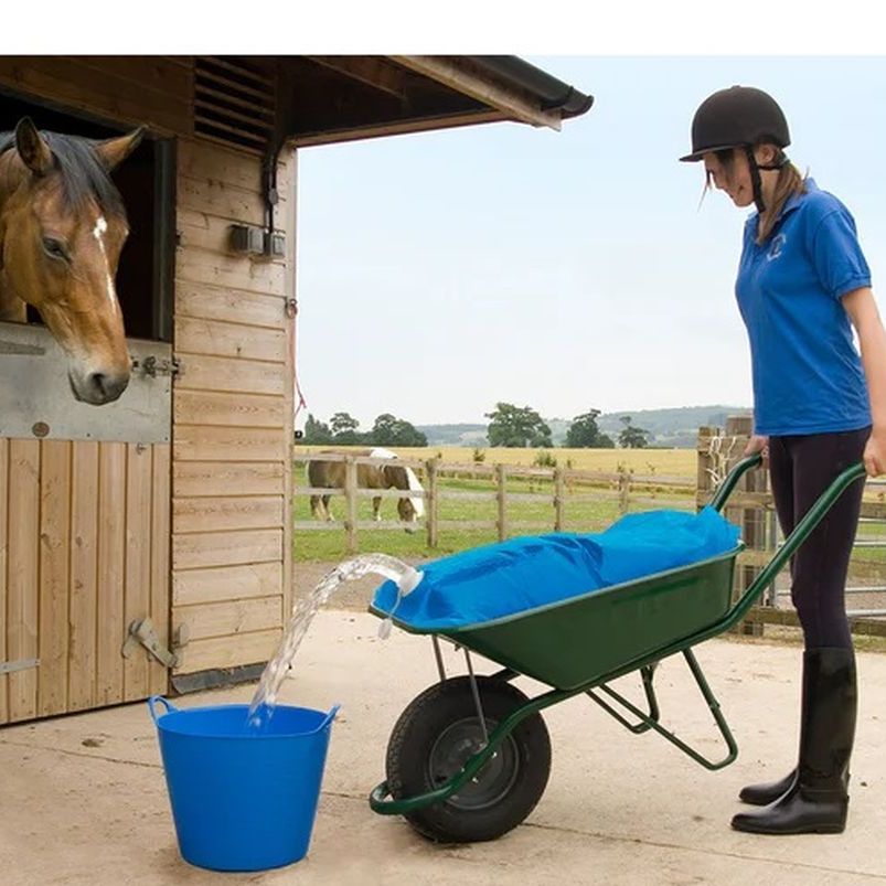 Lady with water bag in wheelbarrow tipping water into bucket