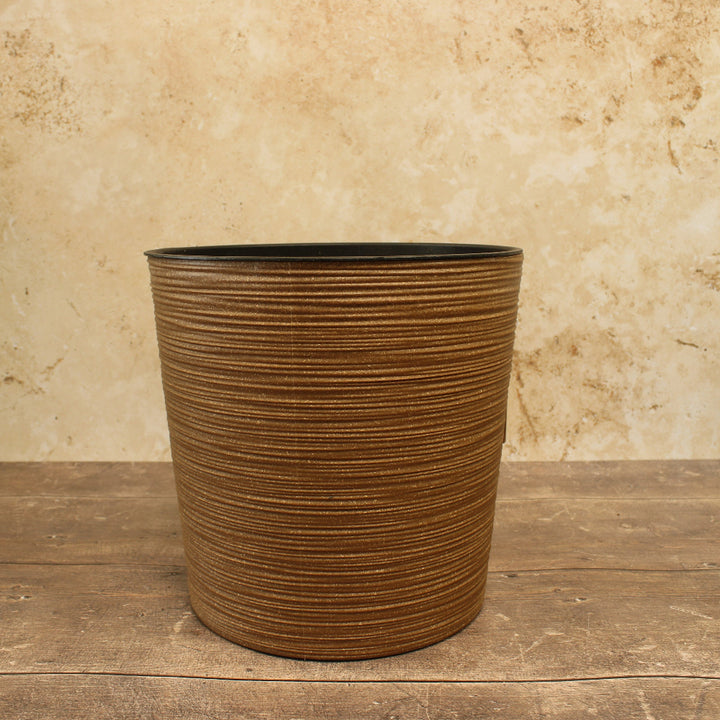 brown plant pot with cream background and wooden floor