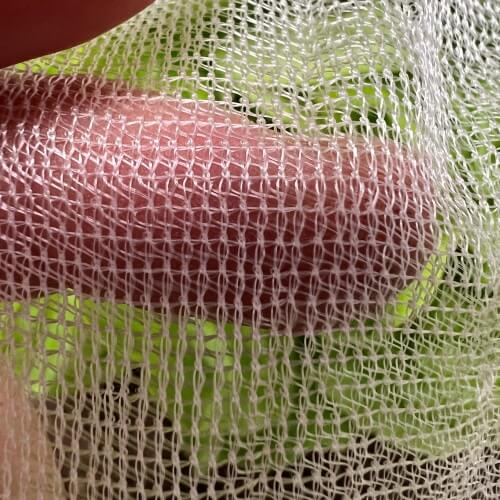 Close-up of a roll of mesh fabric with a green background