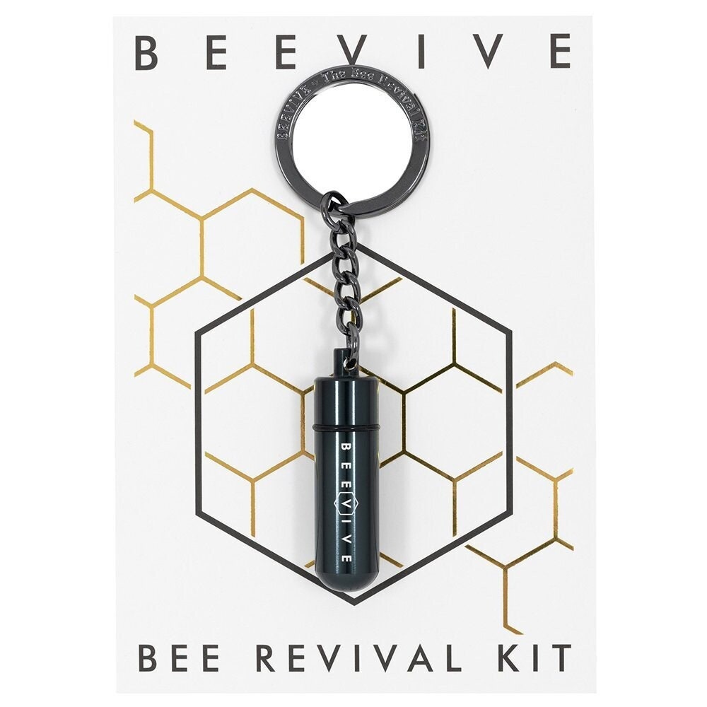A Bee Revival Kit with a gold-colored tube keychain and a gold-colored cap