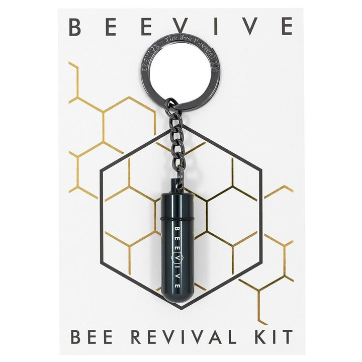 A Bee Revival Kit with a gold-colored tube keychain and a gold-colored cap