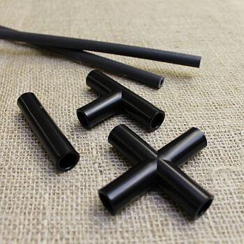 Connectors for black garden hoops sitting on a piece of hessian