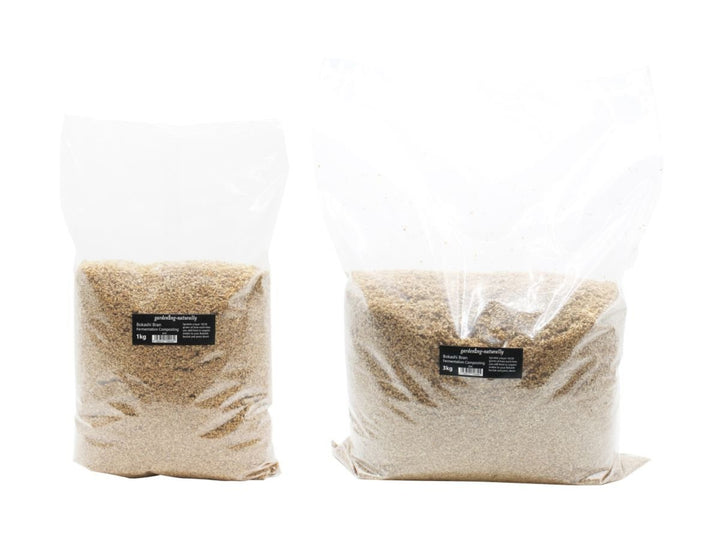Two clear plastic bags filled with bokashi bran and a black label.