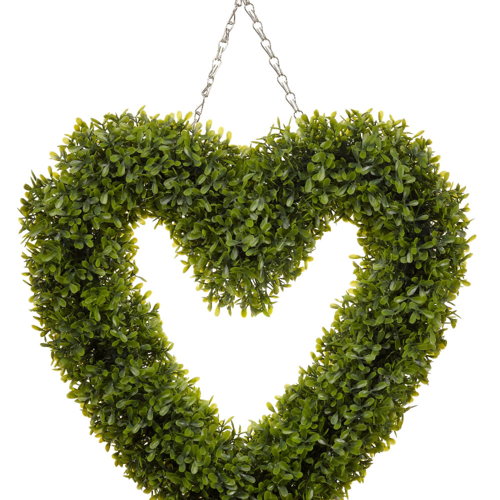 A boxwood heart hanging on a chain with white background