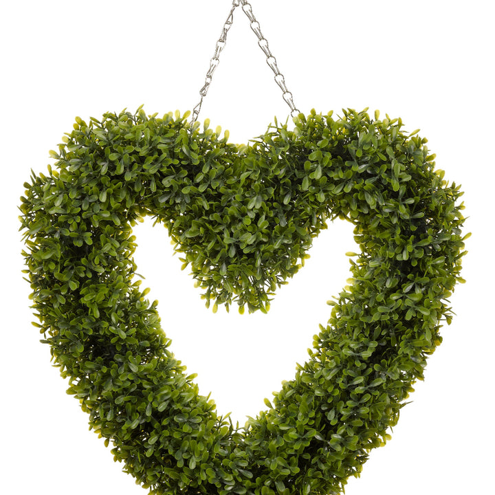A boxwood heart hanging on a chain with white background