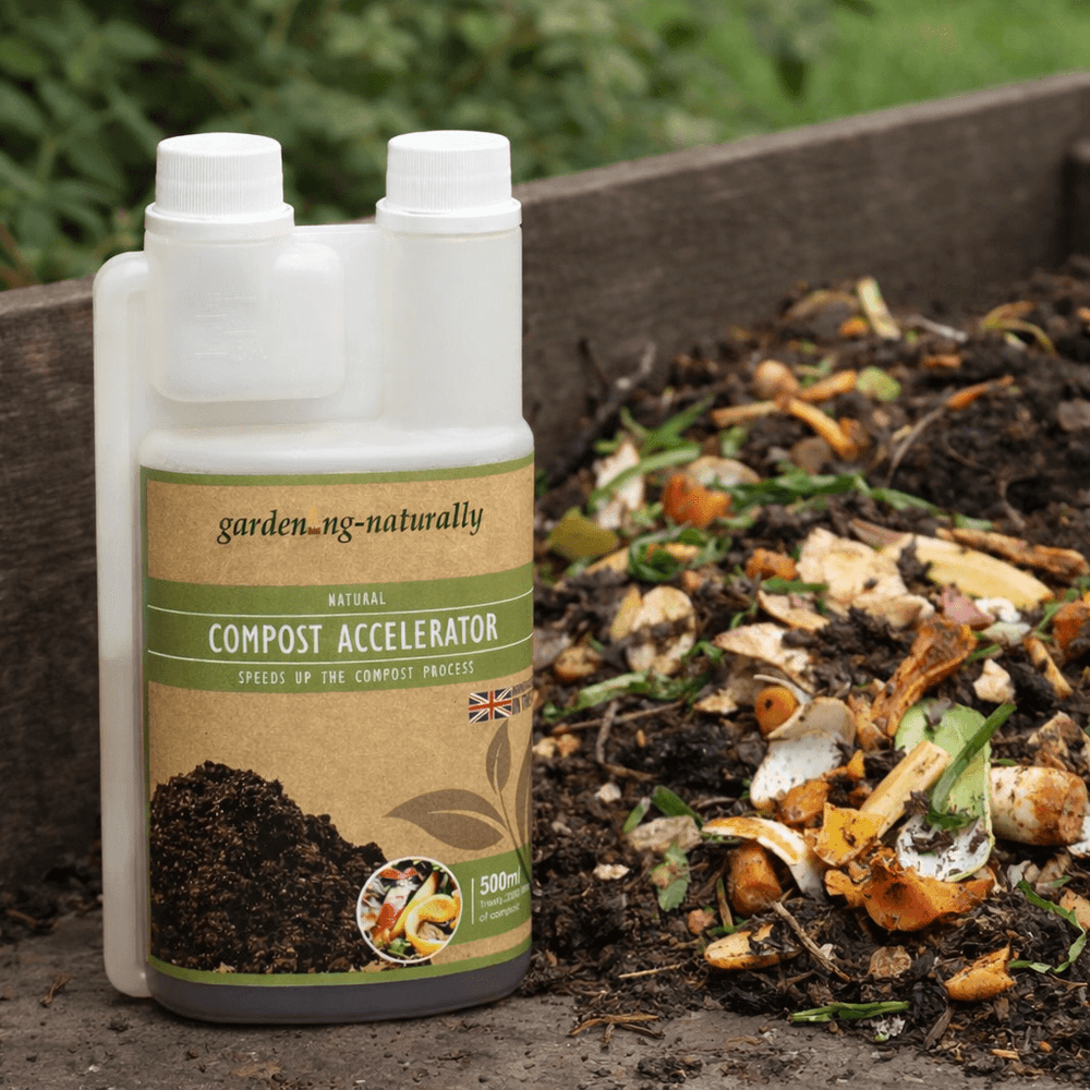 Bottle of compost accelerator next to a pile of compost