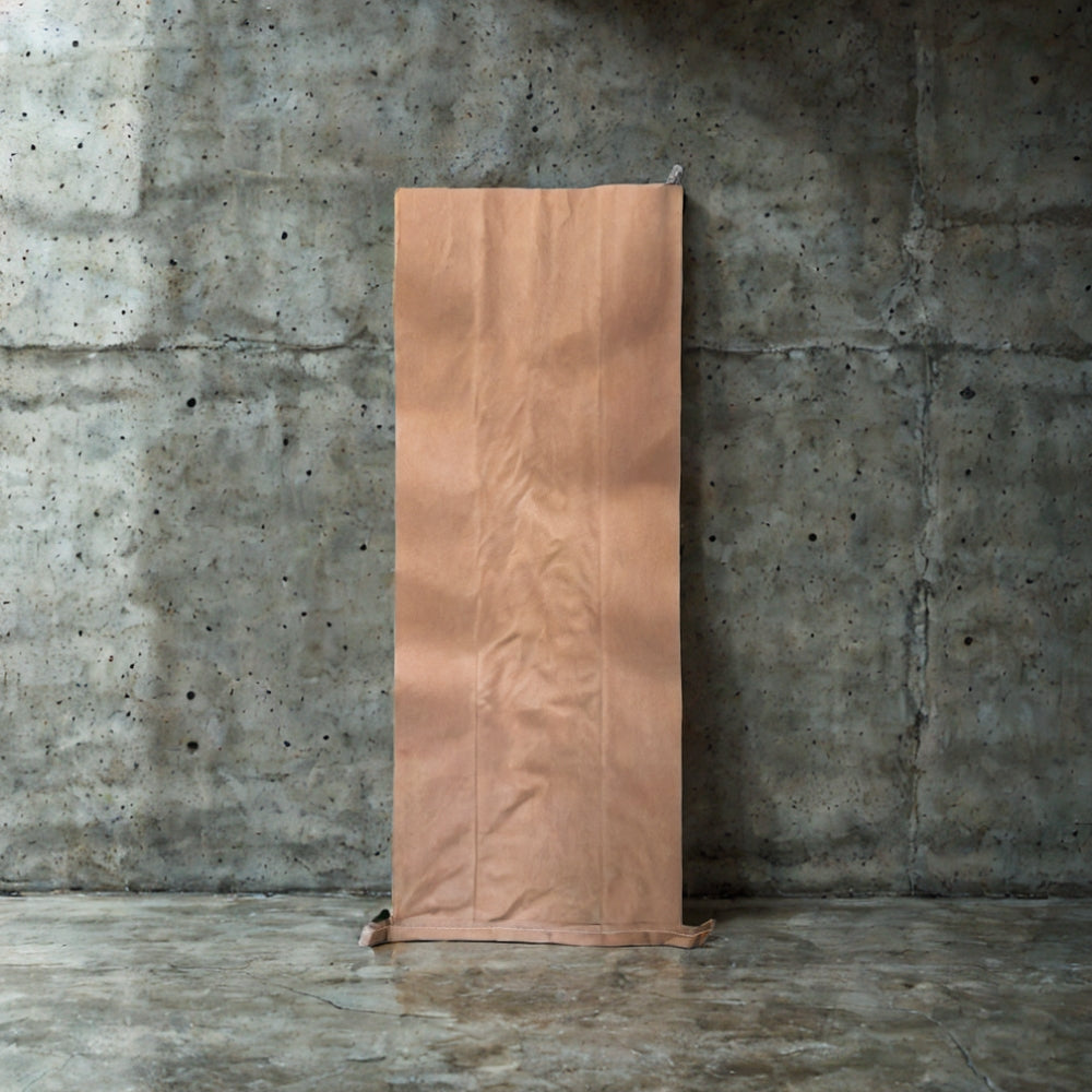 Paper potato sack stood up against a concrete wall