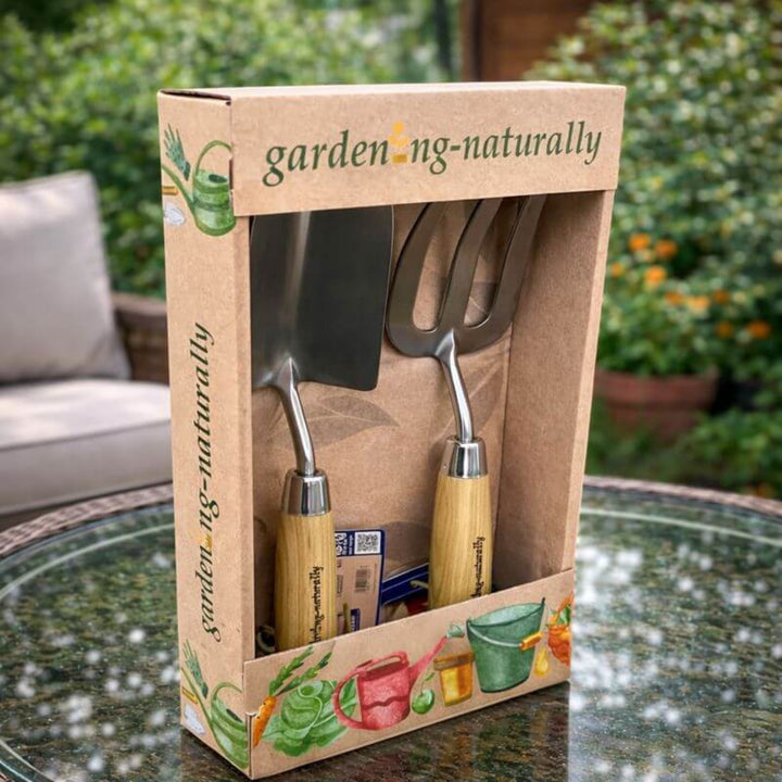 A boxed gardening tool set from gardening-naturally, displayed in an open kraft paper package on table.