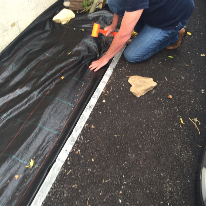 Landscape fabric being laid on drive