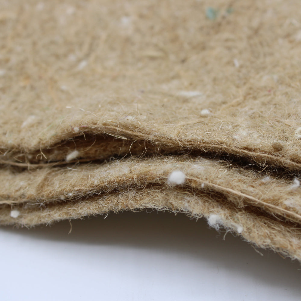 A close-up of a folded, textured tan or beige felt fabric with visible white fibres 