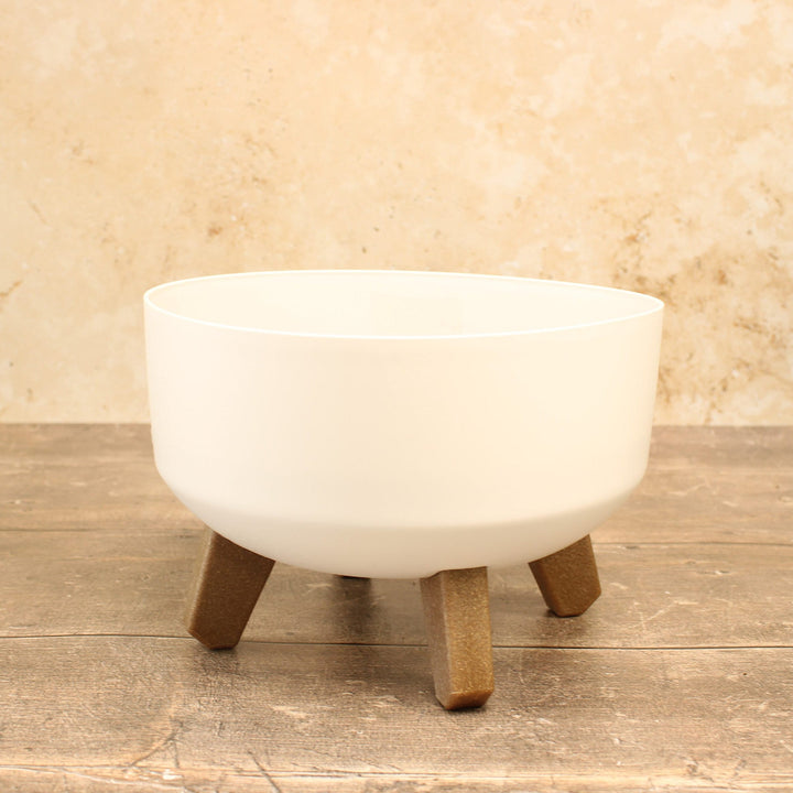 Low plant pots with legs in white Displayed on a wooden surface.