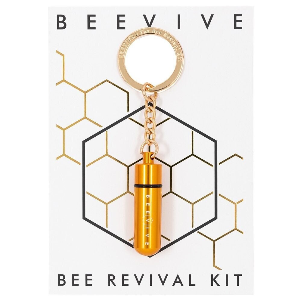 A Bee Revival Kit with a gold-colored tube keychain and a gold-colored 