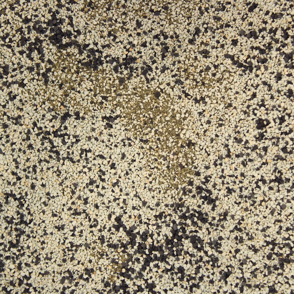 A close-up of root fusion with a mottled pattern of cream, beige, brown, and black flecks.