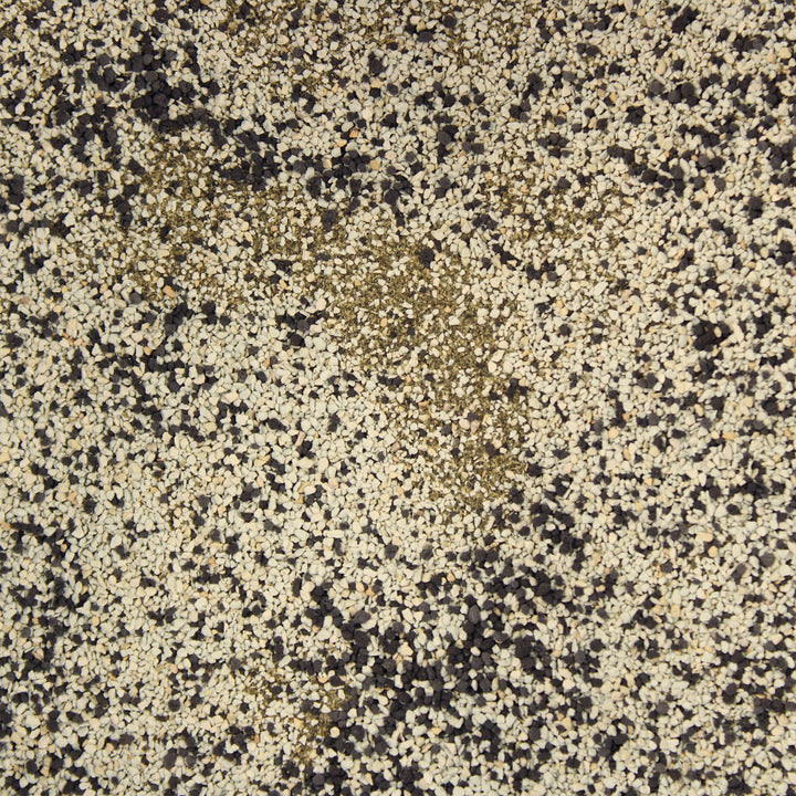 A close-up of root fusion with a mottled pattern of cream, beige, brown, and black flecks.