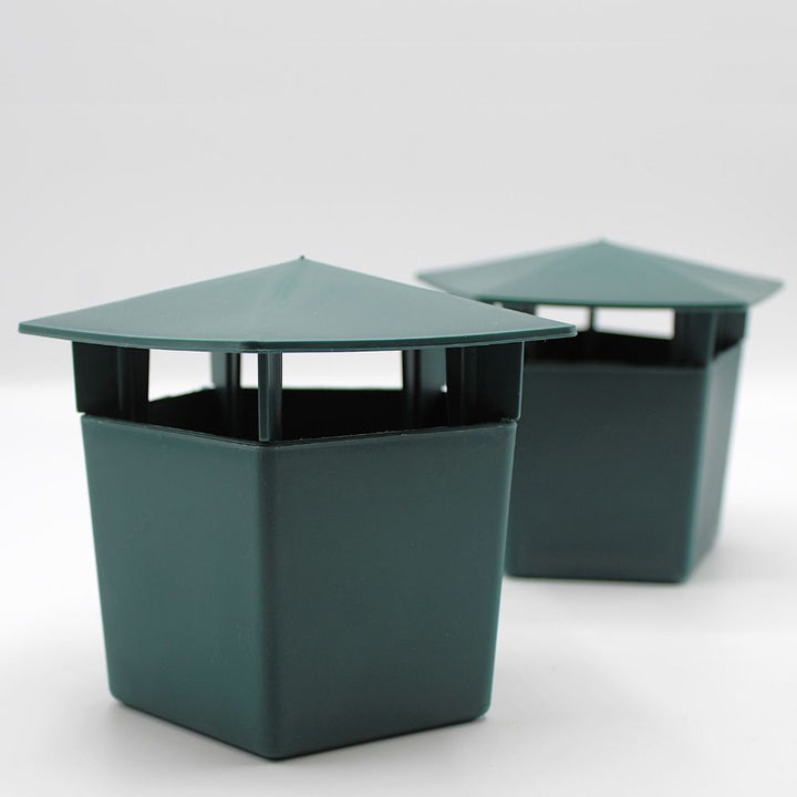 Two green hexagonal trash cans on a white background