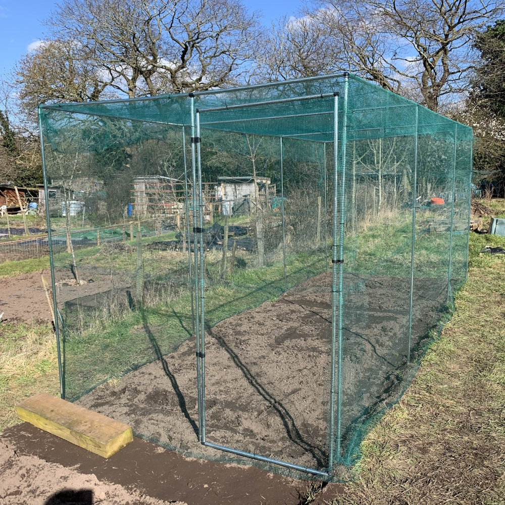green netting walk in vegetable cage in allotment with cage door