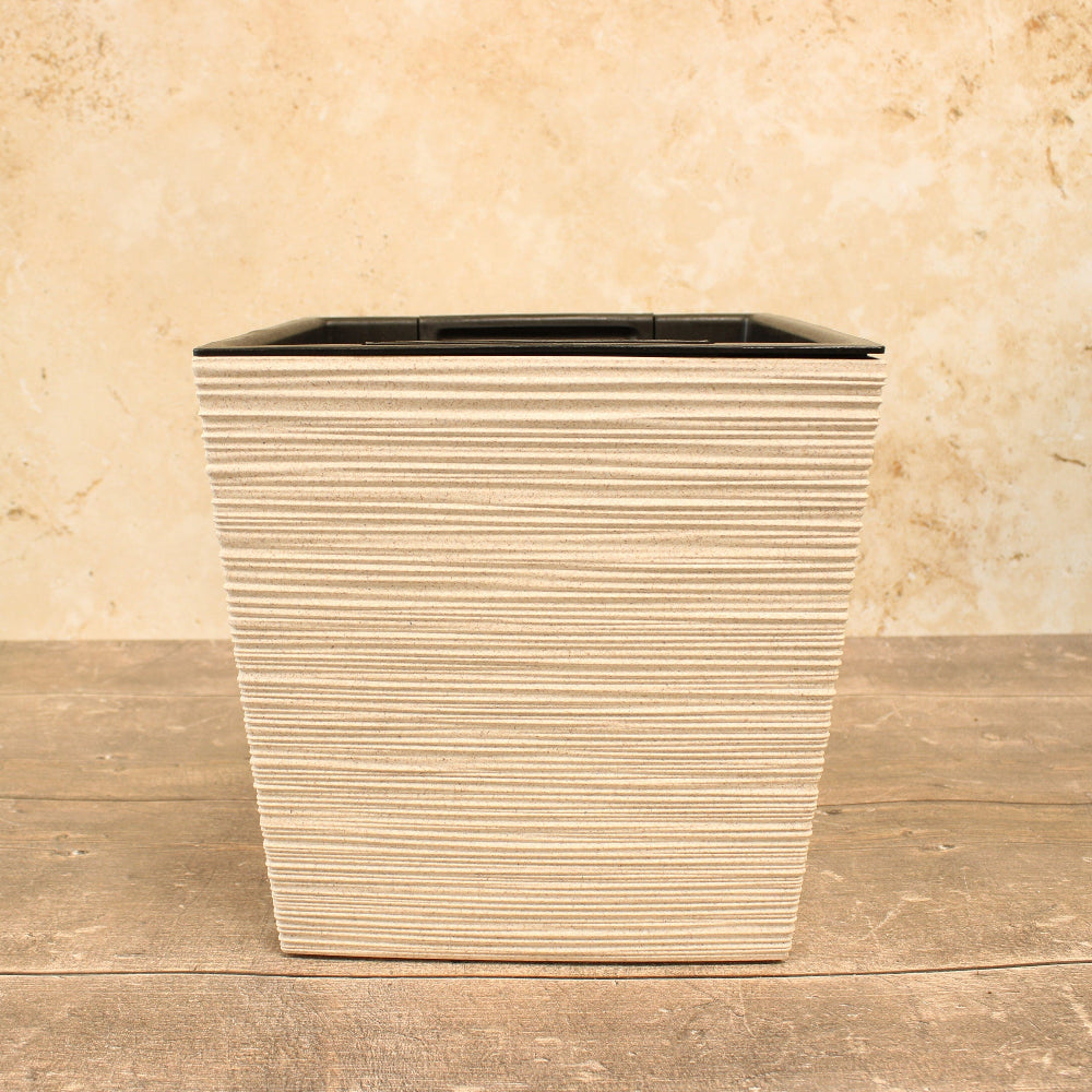White ribbed plant pot on wooden table
